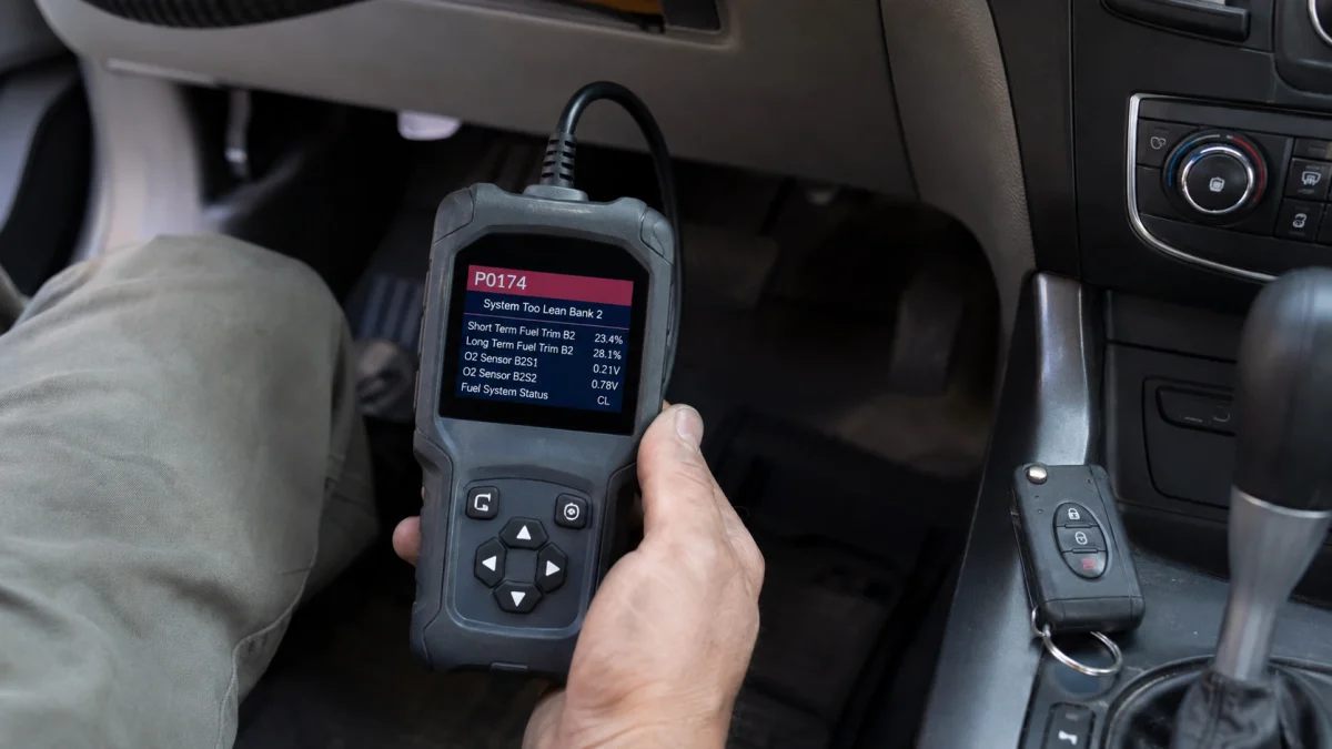 Mechanic using an OBD2 scanner to diagnose P0174 causes