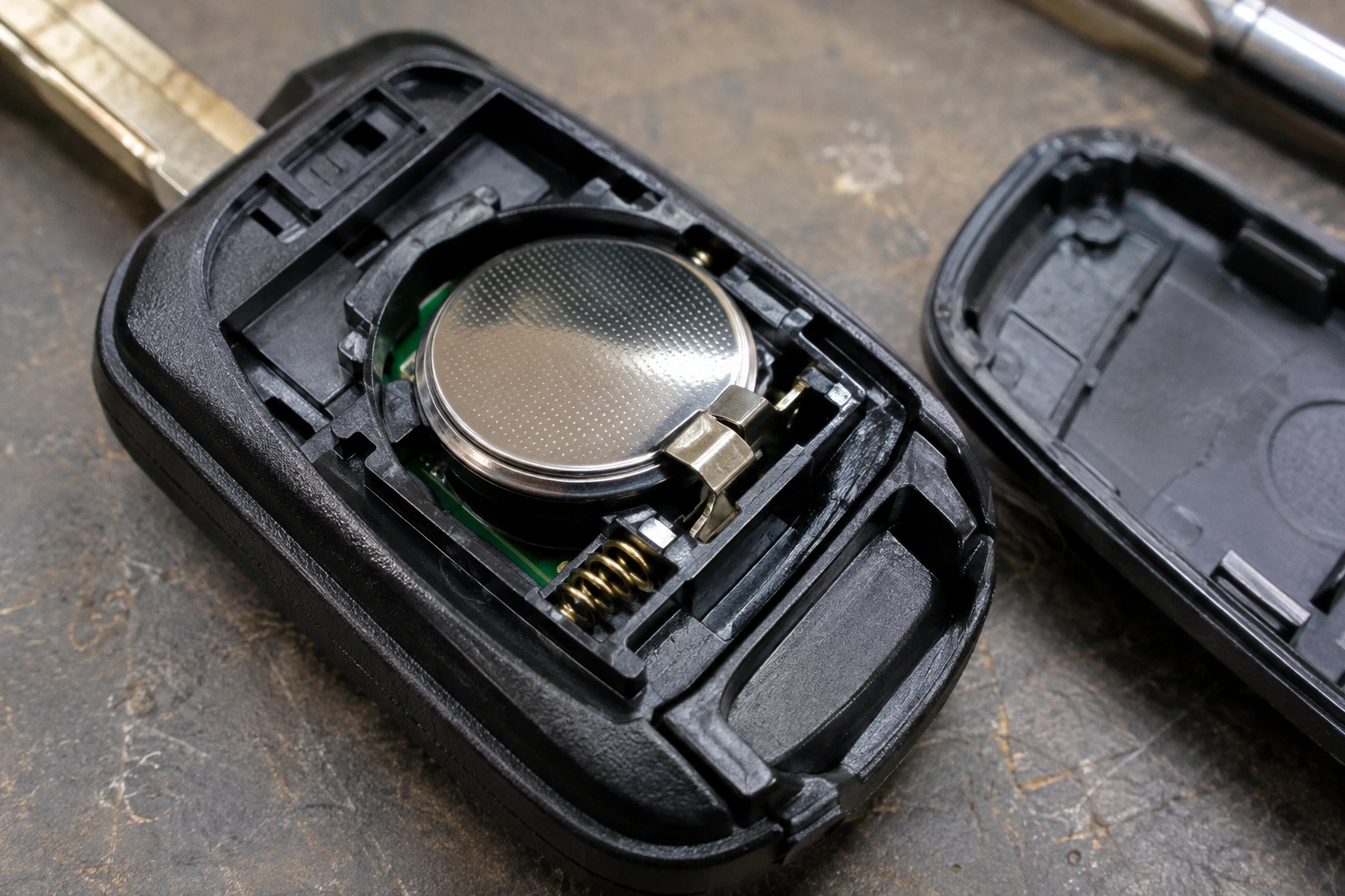 Close-up of a key fob coin cell battery sitting loosely in the holder
